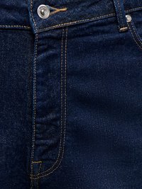 Posnetek v bližini temno modrih jeans hlač, ki prikazuje prednji žep, kovinski gumb in podrobnosti oranžnih šivov.