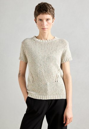 Világos színű kötött pulóver rövid ujjal, kerek nyakkivágással és díszes oldalvágásokkal. Texturált fonalból készült, finom színváltozatokkal.
