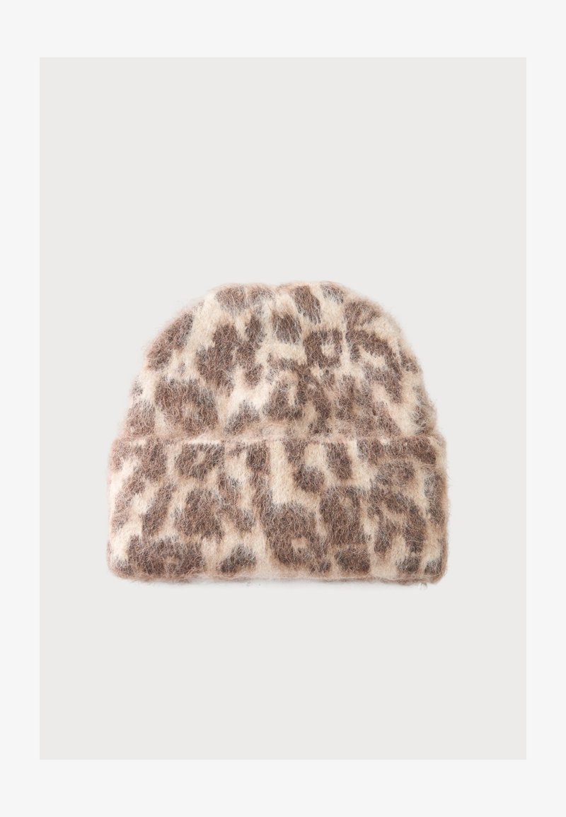 Bonnet doux et duveteux avec bord replié beige et marron à motif léopard sur fond uni.