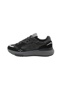 Scarpe da ginnastica nere realizzate con una combinazione di materiali sintetici lisci e suede, dotate di una suola grigia chunky, dettagli in rete e particolari riflettenti.