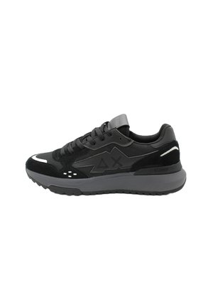 Scarpe da ginnastica nere realizzate con una combinazione di materiali sintetici lisci e suede, dotate di una suola grigia chunky, dettagli in rete e particolari riflettenti.