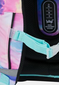 Detail batohu s barevným designem, který zahrnuje růžovo-modrý tie-dye vzor, nastavitelné tyrkysové popruhy, černý síťový vnitřek a systém označeného nastavení.