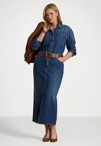 Denim dress with a button-up front and long sleeves, featuring a cinched waist and a long skirt. Brown belt and tan heels complete the look.