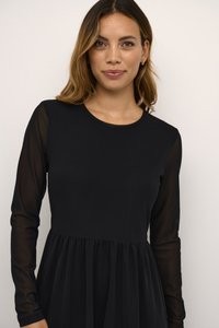 Robe noire avec de longues manches transparentes, encolure ronde et taille froncée. Le tissu semble doux, créant une silhouette fluide et élégante.