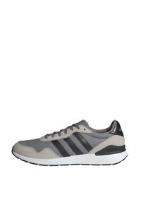 Baskets Adidas grises et noires avec trois bandes, semelle blanche et fermeture à lacets, montrées de profil sur fond blanc.