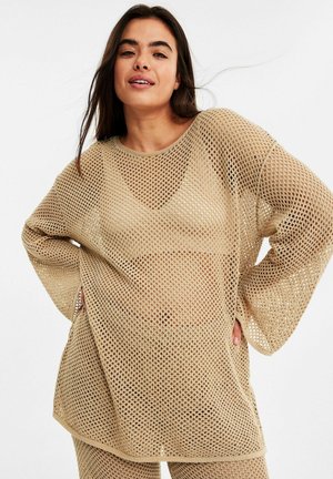 Lichtbeige, oversized mesh trui met lange mouwen en een brede halslijn. Heeft een losse, opengeweven textuur en een ontspannen pasvorm.