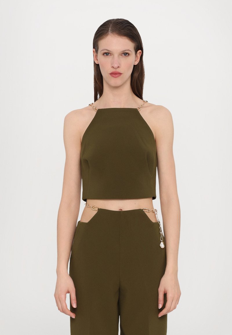 Top scurt de culoare verde măsliniu cu decolteu pătrat și accente din lanțuri de aur pe bretele. Textură netedă, asortat cu pantaloni cu talie înaltă din același material.
