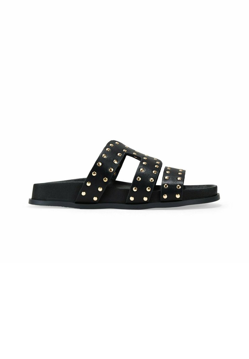 Chanclas negras con tres correas anchas, adornadas con tachuelas doradas, una parte superior texturizada y una suela plana de goma.