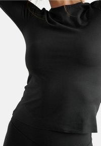 Zwarte longsleeve top gemaakt van gladde, rekbare stof. Heeft een hoge nek en een aansluitende silhouet, met subtiele naaddetails.