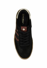 Zwarte suède sneakers met een gestructureerde bovenkant, bruine strepen en zwarte veters. Heeft een tan rubberen zool en een metalen logo detail op de tong.