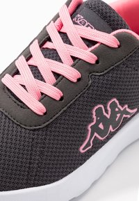 Šedé tenisky s texturovaným síťovaným svrškem, růžovými tkaničkami a bílou podrážkou. Na boku mají růžový logový akcent.