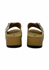 Sandali platform in sughero marrone con punta rotonda, cinturino regolabile alla caviglia, fibbia argentata e suola texturizzata. Design semplice con dettagli minimi.