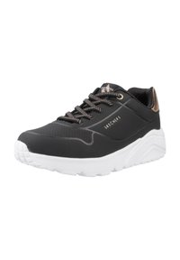 Sneaker nera con tomaia testurizzata, suola in gomma bianca e dettagli metallici. Presenta perforazioni e lacci decorati per un tocco in più.