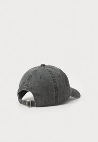 Dark gray cap made of denim with a curved brim, adjustable strap at the back, and stitched detailing along the crown.