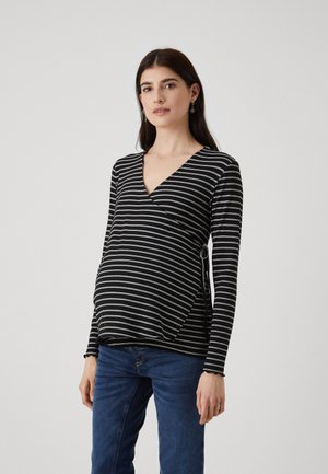 Black and white striped long-sleeve maternity top with a v-neck and wrap design, featuring a side tie detail. Soft texture.