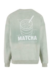 Hanorac mint cu un grafic mare alb reprezentând o băutură matcha cu gheață, cu un pai și detalii textuale pe spate. Textură moale.