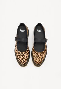 Luipaardprint Mary Jane-schoenen met een zwarte riem en rubberen zool. Heeft een gladde textuur en gele stiksels rondom de randen.