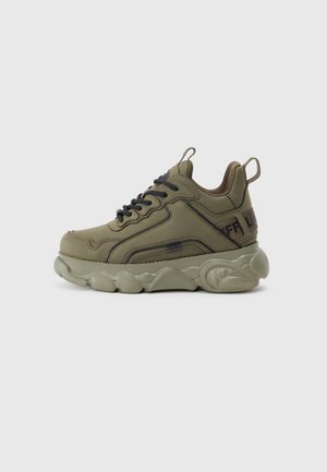 Olijfgroene sneaker met gestructureerde bovenkant, zwarte veters en comfortabele zool. Opmerkelijke details zijn onder andere zijnaadstiksels en een trekband aan de achterkant.
