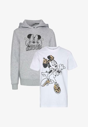 Biała bawełniana koszula z krótkim rękawem z nadrukiem postaci z kreskówki, w której znajduje się leoparda wzór kokardy i butów, zestawiona z jasnoniebieskimi podwiniętymi dżinsami i beżowymi trampkami.