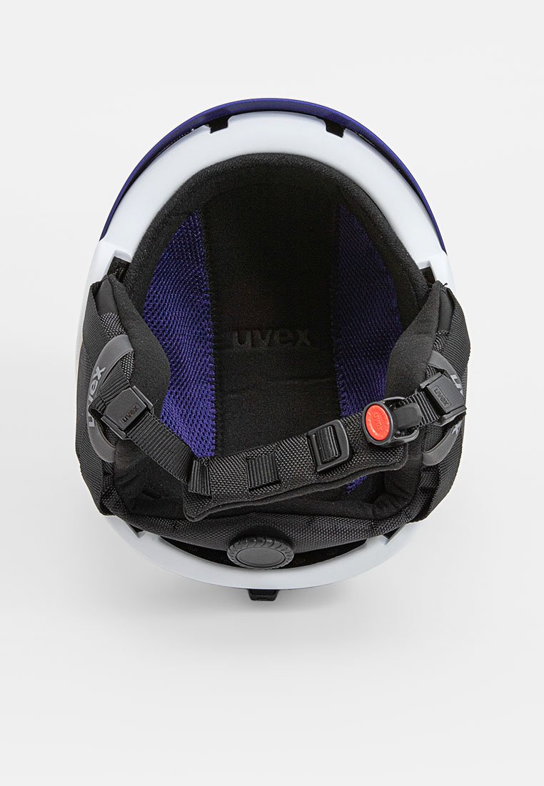 Innerer Teil eines weißen Helms mit schwarzen Riemen und lila Innenfutter. Verfügt über einen verstellbaren Drehknopf und einen Schnellverschluss. Glatte Oberflächenstruktur.