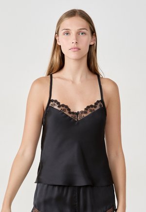 Camisole en satin noir avec des détails en dentelle le long de l'encolure. Bretelles réglables et texture lisse, présentant une coupe décontractée et un design en V.