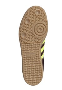 Soletta in gomma beige con motivo di grip testurizzato, caratterizzata da tre strisce gialle e un logo "adidas" in rilievo. Dettaglio circolare sul tacco.