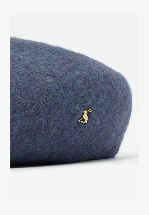 Filcowy beret w głębokim niebiesko-szarym odcieniu, z teksturowaną powierzchnią i małym złotym akcentem w postaci królika po boku.