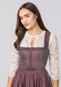 Traditionelles Kleid mit einem mauvefarbenen Oberteil mit strukturierten Akzenten, Spitzenärmeln und aufwendigen silbernen Verzierungen an der Taille.