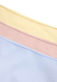 Piezas de tela dobladas en colores amarillo suave, rosa y azul claro, dispuestas en diagonal sobre un fondo blanco.