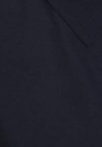 Marineblau gestrickter Stoff mit einer glatten Textur, der einen Kragen und ein dezentes Muster aufweist. Einheitliche Farbe mit leichtem Glanz des Stoffes.