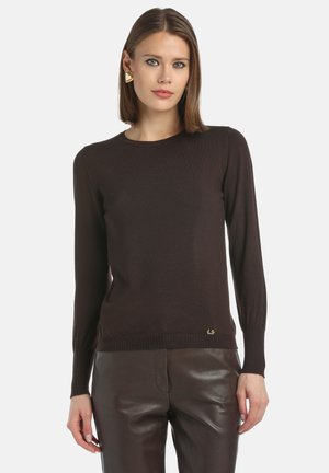 Maglione marrone a maglia con maniche lunghe e scollatura rotonda; presenta polsini e orlo a coste, arricchito da un piccolo logo dorato in basso.