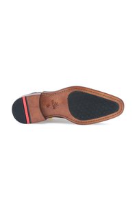 Semelle en cuir brun avec un talon en caoutchouc noir, texture antidérapante à la base, et accent de bande rouge sur le côté.