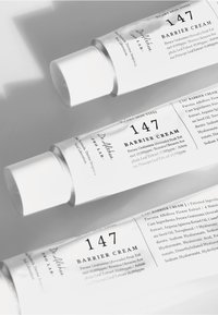 147 Barrier Cream i hvite rør med teksturerte korker, svart tekst og detaljer om ingredienser; designet for tørr hud.