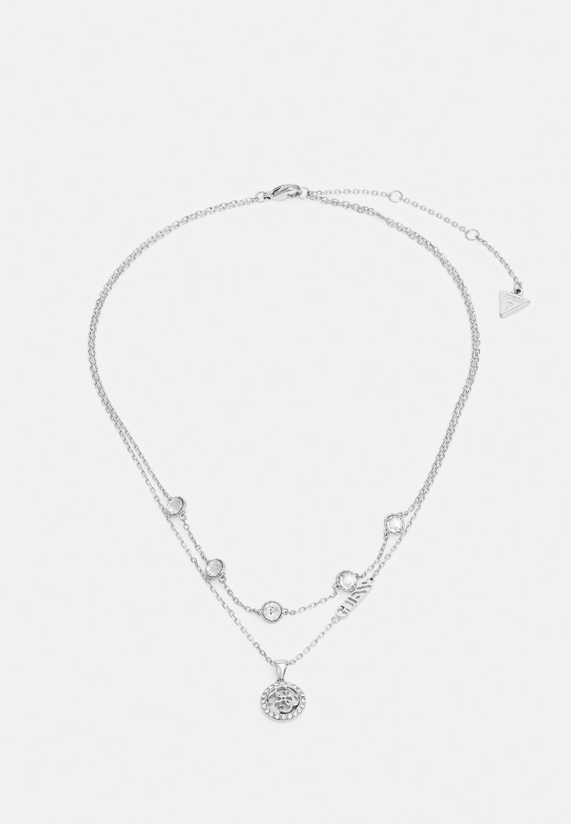Silberne, mehrlagige Halskette mit Perlendetails, einem runden Anhänger mit Verzierungen und einem Logo-Tag an einer filigranen Kette.