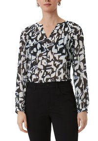 Transparante zwarte blouse met abstracte witte en blauwe patronen, met lange mouwen, een v-hals en geplooide schouderdetails.