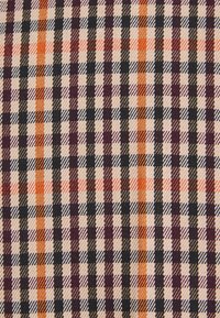 Tissu à carreaux présentant un motif de carrés alternés en violet foncé, noir, orange et beige, avec une finition tissée texturée.