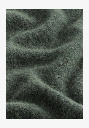 Tessuto di lana verde con una superficie morbida e testurizzata, caratterizzato da sottili variazioni di tonalità e densità, creando un aspetto ondulato.