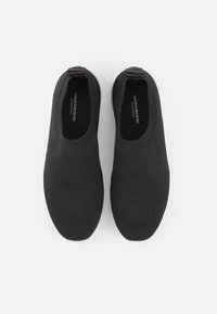 Svarte slip-on sko laget av teksturert strikkemateriale. Rund tå og fleksibel design med en lavprofilert, minimalistisk utseende.