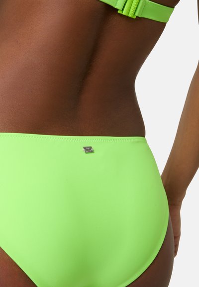 Zelené bikiny s hladkým materiálem, minimalistickým designem a malým kovovým logem v blízkosti pasu.