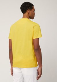 Geel t-shirt met korte mouwen in een gladde textuur, met een ronde halslijn en een ontspannen pasvorm. Dit shirt heeft een nette stitching en een simpel ontwerp.