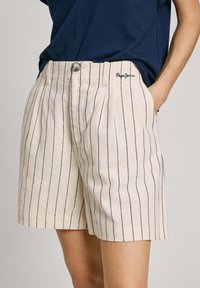 Shorts beige in lino con righe verticali blu scuro, dotati di chiusura frontale con bottone e tasche laterali. Logo Pepe Jeans ricamato sulla cintura.