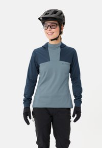 Maglia da ciclismo a maniche lunghe grigia e blu navy, realizzata in tessuto elastico. Presenta un cappuccio e una vestibilità aderente, con un logo sul petto e guanti.