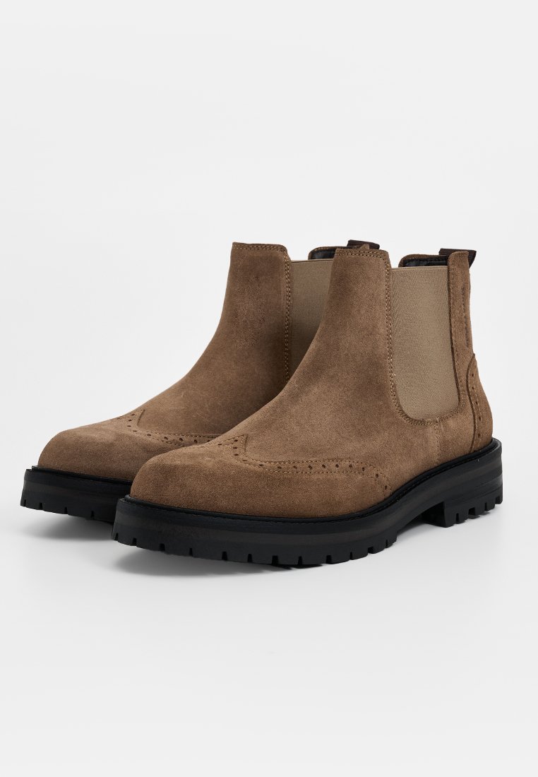 Braune Wildleder Stiefeletten mit einer glatten Textur, elastischen Seitenpaneelen und Broguemuster; Gummisohle mit einem kräftigen Profil.