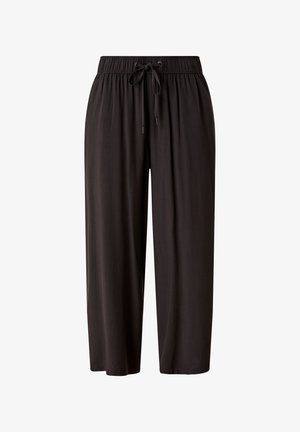 Pantalon large noir avec une taille élastique, des plis et des poches latérales. Associé à des sandales à enfiler gris clair avec une bride épaisse.