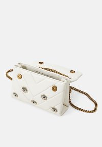 Vit kviltad läderhandväska med ett chevronmönster, prydd med guldtonad hårdvara och dekorativa ögonmotiv. Inkluderar en kedjestrap.