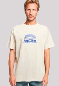 Beige Baumwoll-T-Shirt mit einem Retro-Grafik einer blauen Autos und dem Text "Retro Car" darunter, entspannte Passform und kurze Ärmel.