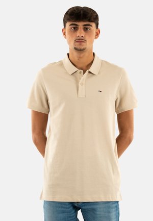 Beige polo shirt gemaakt van katoen met een klassieke kraag, placket met drie knopen en een klein logo op de linkerborst. Korte mouwen.