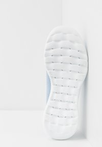 Scarpa sportiva di colore azzurro chiaro con tomaia in mesh testurizzato e suola in gomma bianca con battistrada a motivo per una migliore trazione.