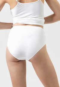 Calzoni alti in cotone bianco con una texture liscia e una vita elastica, visti da dietro, che mostrano un design minimal.