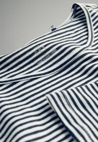 Gestreiftes Baumwoll-T-Shirt in Schwarz und Weiß mit rundem Ausschnitt, versehen mit einem Etikett, auf dem der Markenname "SET" aufgedruckt ist.
